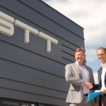Menno Kooistra (rechts) van STT Products en Martin van der Have van ABB Robotics schudden elkaar de hand bij het nieuwe pand van STT Products in Tolbert, dat op 20 mei feestelijk wordt geopend.