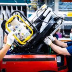 Medewerkers van VDL Nedcar die aan de assemblagelijn dicht bij elkaar werken, zijn onder meer uitgerust met persoonlijke beschermingsmiddelen, zoals mondkapjes, veiligheidsbrillen en handschoenen. (Foto: VDL)