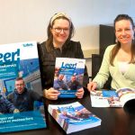 Evelien Harbers (links) van Marketing & Communicatie en HRD-specialist Marianne Mosselman met de eerste uitgave van Leer!